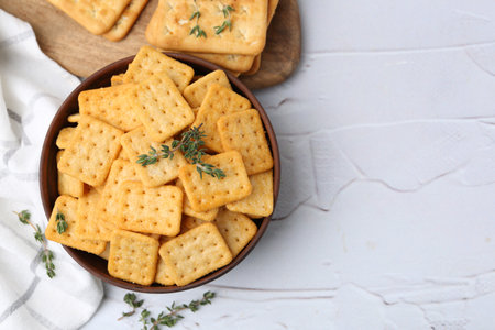 Tasty salty crackers and thyme on white textured table, flat lay. Space for textの写真素材