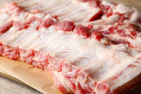 Raw pork ribs on wooden table, closeup