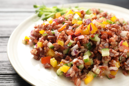 Tasty salad with brown rice on black wooden table, closeupの写真素材