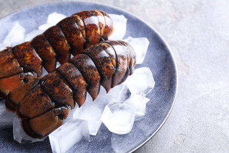 Raw lobster tails with ice on grey table, closeupの写真素材