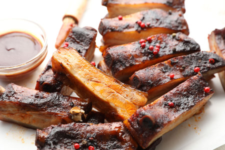 Delicious pork ribs and sauce on parchment paper, closeupの写真素材