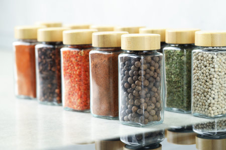 Many different aromatic spices in jars on table indoors, closeup