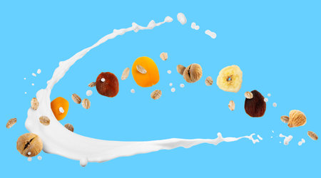 Milk splash with oat flakes and dried fruits on light blue background. Banner designの写真素材