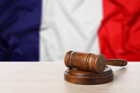 Judge's gavel on wooden table against flag of Franceの写真素材