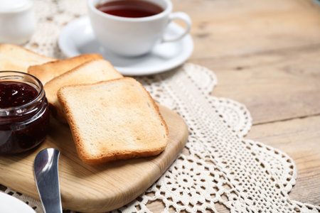 Slices of tasty toasted bread and jam on wooden table, closeup. Space for textの写真素材
