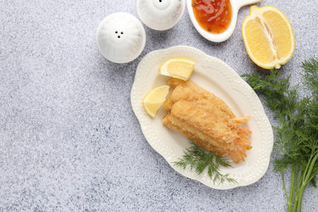 Tasty tempura shrimps served with sauce on gray textured table, flat lay. Space for text