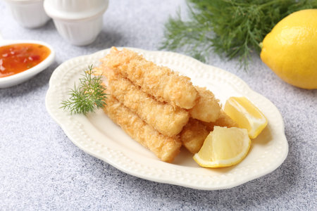 Tasty tempura shrimps, lemon and dill on grey textured table, closeup