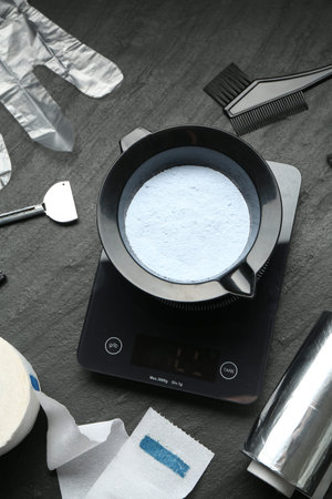 Bleaching powder and hairdresser's tools on black table, flat layの写真素材