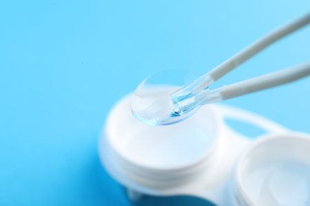 Taking contact lens from case on light background, closeup. Space for text