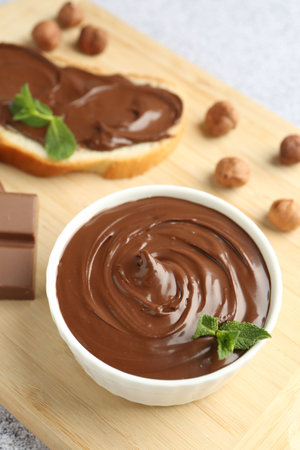 Tasty chocolate hazelnut spread with mint in bowl on gray tableの写真素材