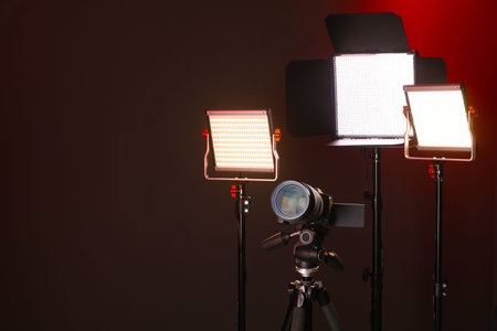 Professional lighting equipment and camera on color background. Space for text