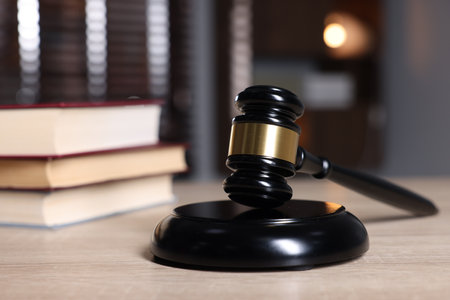 Judge's gavel and sound block on wooden table against blurred background, closeupの写真素材