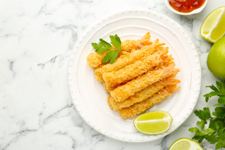 Tasty tempura shrimps served on white marble table, flat lay. Space for text