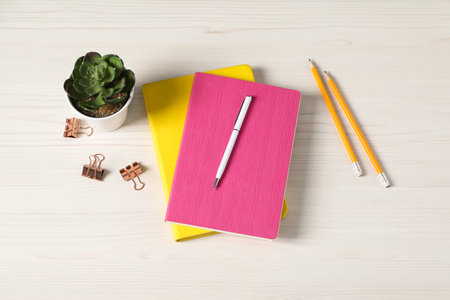 Flat lay composition with office supplies and houseplant on light wooden tableの写真素材