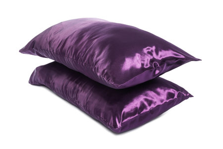Pillows in purple pillowcases isolated on white. Silk bed linensの写真素材
