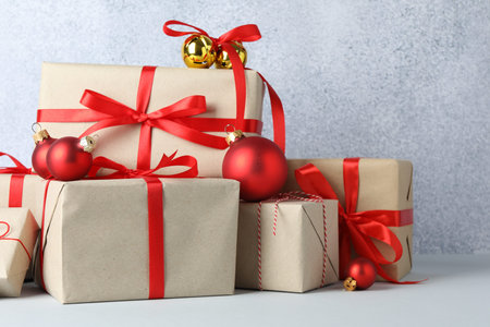 Many gift boxes wrapped in kraft paper and Christmas decor on light table