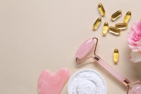Flat lay composition with collagen capsules and flower on beige background. Space for textの写真素材