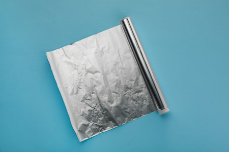 Roll of aluminum foil on light blue background, top viewの写真素材