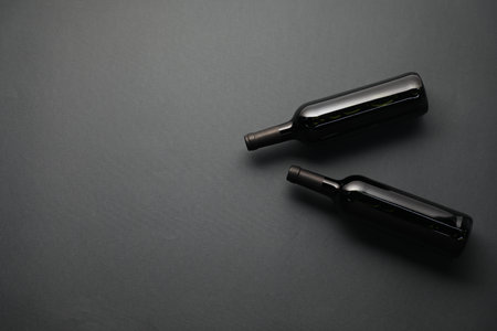 Bottles of wine on grey background, flat lay. Space for textの写真素材