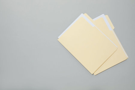 File folders with papers on gray background, top view. Space for text