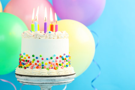 Delicious bento cake with sprinkles and candles on light blue background, closeup. Space for textの写真素材