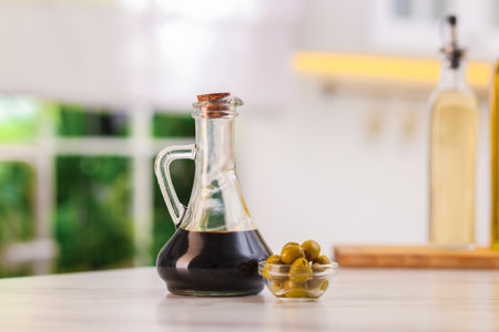 Balsamic vinegar and olives on table in kitchenの写真素材
