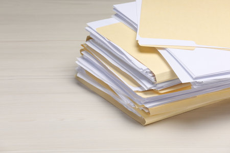 File folders with papers on wooden table, closeup. Space for text