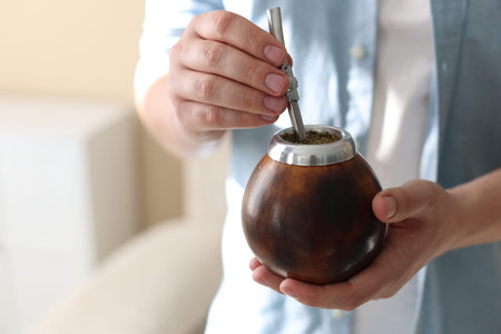 Man with traditional yerba mate tea at home, closeup