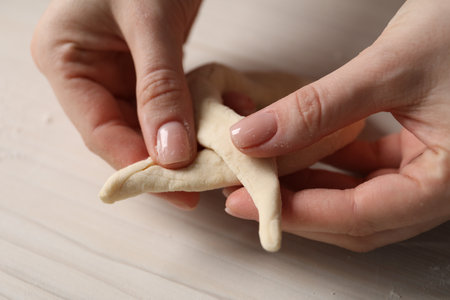 Woman making pretzel at white wooden table, closeupの写真素材
