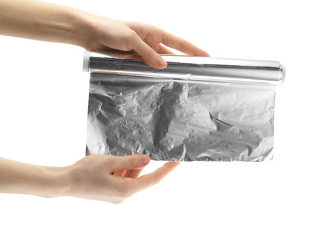 Woman holding roll of aluminum foil on white background, closeupの写真素材