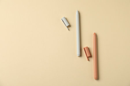 Stylish pens on beige background, flat lay. Space for textの写真素材