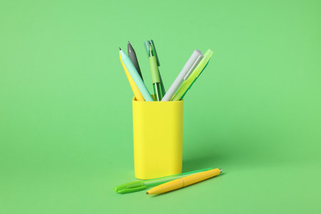 Ballpoint pens in holder on green background, closeupの写真素材