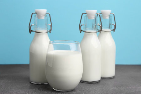 Fresh milk on grey table against light blue backgroundの写真素材