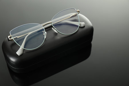 Stylish glasses and case on grey mirror surface, closeupの写真素材