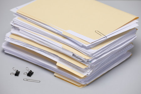 File folders with papers and binder clips on gray background, closeupの写真素材