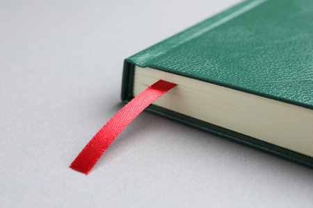 Book with red ribbon bookmark on light grey table, closeupの写真素材