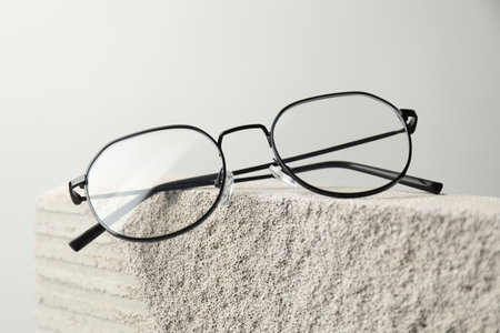 Stylish glasses on stone surface against light grey background, closeupの写真素材