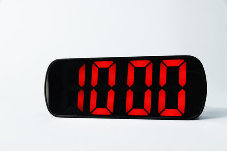 Digital alarm clock showing 10:00 o'clock on grey backgroundの写真素材