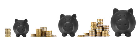 Piggy banks of different sizes and stacked coins on white backgroundの写真素材