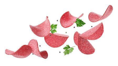 Salami sausage slices, peppercorns and parsley flying on white backgroundの写真素材
