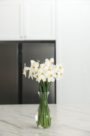 Beautiful daffodils in vase on white marble table indoorsの写真素材