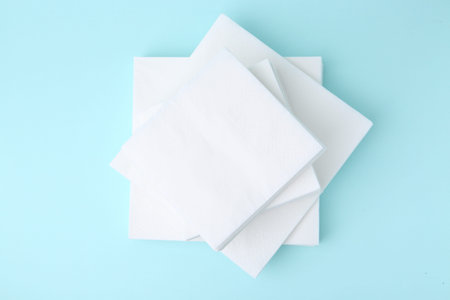 Stack of disposable paper handkerchiefs on light blue background, top viewの写真素材