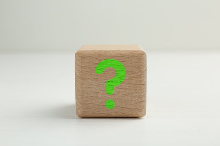 Wooden cube with question mark on light grey background, closeupの写真素材