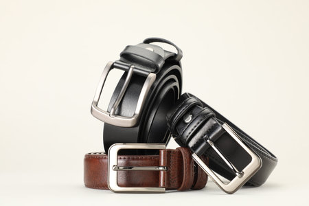 Three color leather belts on white background, space for text