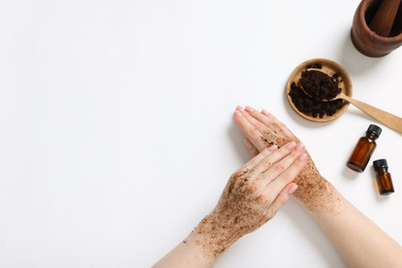 Woman applying body scrub onto her hand on white background, top view. Space for textの写真素材