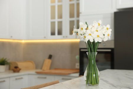 Beautiful daffodils in vase on white marble table indoors, space for textの写真素材