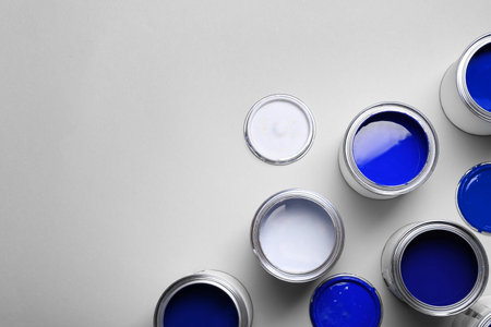 Cans with paint in shades of blue on light grey background, top view. Space for textの写真素材
