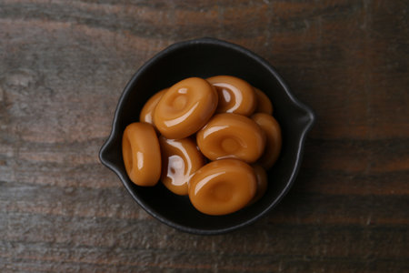 Tasty sweet caramel candies on wooden table, top viewの写真素材
