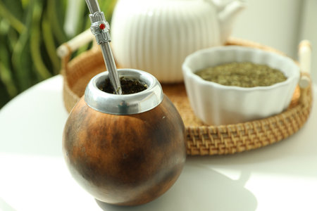 Traditional yerba mate tea on white table indoors, closeup