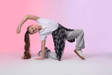 Girl in stylish clothes dancing on color background